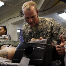 U.S. Army Chaplain CPT. Loren Aderhold prays over a wounded American soldier at the military hospital on March 22, 2010 at Kandahar Airfield, Afghanistan. 