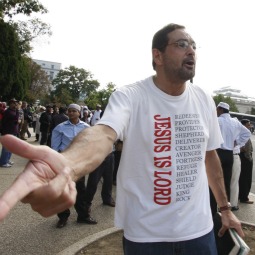 MESSENGER. Evangelist Lazaro Lopez shouts to Muslims to accept Jesus Christ as their lord and savior as they wait for their buses to arrive in Washington Sept. 25, 2009. Nearly 3,000 Muslims from around the United States gathered outside the U.S. Capitol for "jummah," a congregational prayer held on Fridays. A similar encounter in Michigan has led to a lawsuit against the city of Dearborn for its restrictions against an evangelical group.
