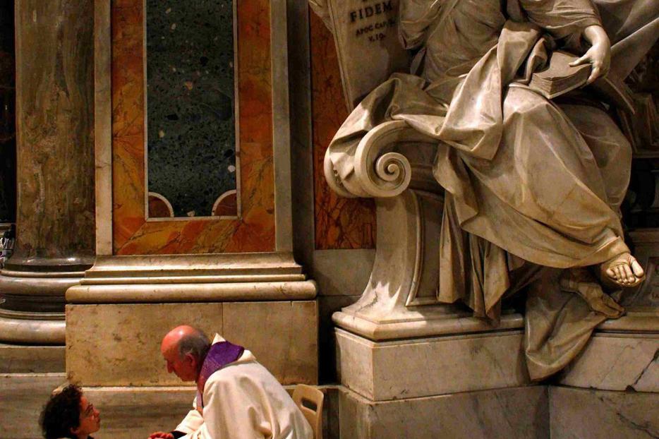 A priest hears a confession during a penitential celebration at St. Peter's Basilica.