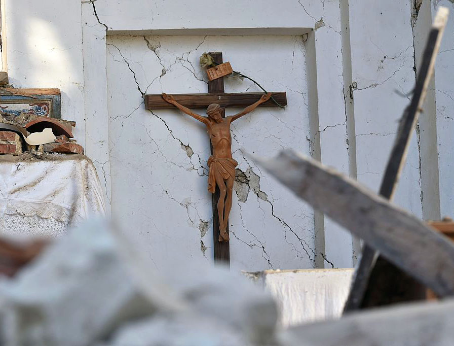 A picture taken on August 27, 2016 shows a crucifix in a damaged church in San Lorenzo, near the Italian village of Amatrice, three days after a 6.2-magnitude earthquake struck the region.