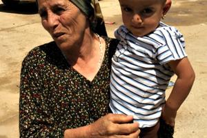 An woman and child at a refugee camp in Erbil, Iraq. The woman claims her husband was kidnapped by the Islamic State group. Below, Father Benedict Kiely of the Diocese of Burlington, Vt., with a group of Dominican nuns who minister to Iraqi refugees, and Christian refugees make do at one of the camps.