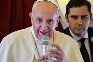 Pope Francis addresses reporters aboard the plane bringing him back following a two-day trip to Morocco March 31, as interim director of Holy See Press Office, Alessandro Gisotti looks on.