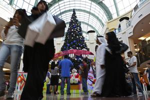 An Emirati couple and people of other nationalities pass by a giant Christmas tree at a shopping mall in Dubai, United Arab Emirates. Pope Francis will make the first papal visit to the Arabian Peninsula next month.  