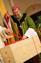Bishop Jenky ties a ribbon around a crate of documents for Archbishop Sheen's cause.
