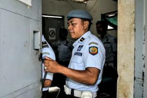 An officer closes the gate of Kerobokan prison in Indonesia, where Myuran Sukuraman and Andrew Chan are jailed, Feb. 10.