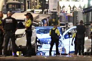 A damaged van, believed to be the one used in the attack, is surrounded by police officers in the Las Ramblas area on Aug. 17 in Barcelona, Spain. 