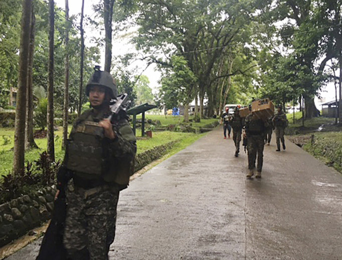 Philippine troops arrive at their barracks to reinforce fellow troops following the siege by Muslim militants May 24 on the outskirts of Marawi city in the southern Philippines. The militants burned buildings and took hostages. 