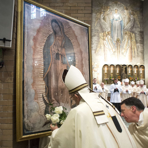 Pope Francis places a bouquet of roses in front of Our Lady of Guadalupe image at the conclusion of Mass celebrated at the Pontifical North American College in Rome on May 2, 2015.
