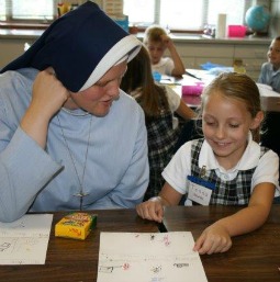  Sister Regina Marie of the School Sisters of Christ the King talks with a young student.