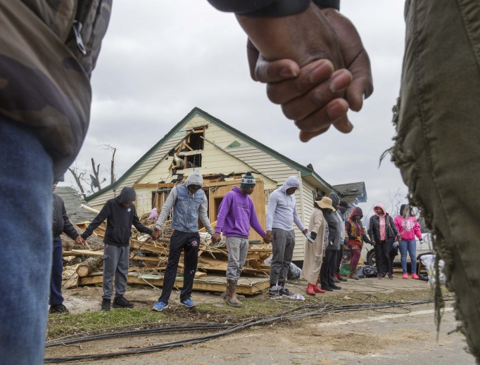 Residents of Talbotton, Georgia, pray together March 4 outside a home destroyed by a tornado; the moment of prayer came the day after storms battered Alabama and Georgia.