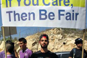 A demonstrator in Jerusalem carries a sign asking the government for educational equality.