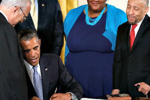 U.S. President Barack Obama signs an executive order on workplace discrimination July 21 at the White House in Washington. The executive order bars workplace discrimination in the federal government and its contracting agencies on the basis of sexual orientation and gender identity.