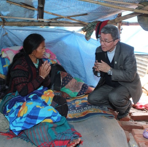Bishop Paul Simick of Nepal visits an earthquake victim.