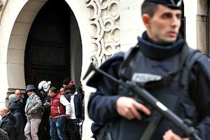 Armed police officers stand outside the Grand Mosque on Jan. 9 in Paris.