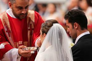 A couple newly married by Pope Francis receives Communion in St. Peter’s Basilica on Sept. 14, 2014.
