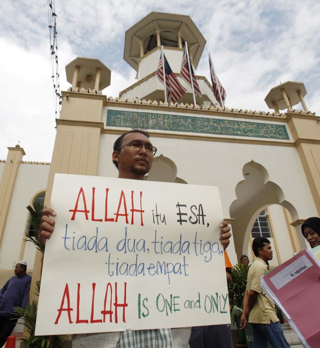 ANTI-CATHOLIC ANGER. A Muslim demonstrator displays a placard to members of the media outside a mosque in Kuala Lumpur, Malaysia, Jan. 8. Some Muslims protested a recent court decision that allows a Malaysian Catholic newspaper to use the word ‘Allah’ to describe God. The placard reads: ‘Allah is one, not two, not three, not four. Allah is one and only.’