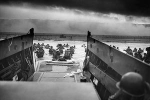 A landing craft from the U.S. Coast Guard-manned USS Samuel Chase disembarks troops of Company E, 16th Infantry, 1st Infantry Division (the Big Red One) wading onto Omaha Beach on the morning of June 6, 1944. During the initial landing two-thirds of Company E became casualties.