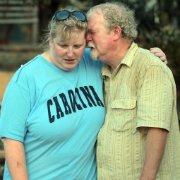 Billy Stinson and his daughter Erin comfort each other Aug. 28 as they stand next to a pile of debris which was once their cottage in Nags Head, N.C.