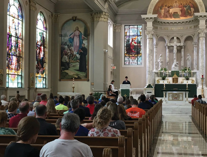 Above, students pray at Mass at St. John’s Catholic Newman Center at the University of Illinois. Below, students pray at ‘Magnify,’ an event that combines praise and worship music with Eucharistic adoration, at St. Mary’s Catholic Center at Texas A&M University. 