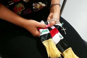 Iraqi woman holding a rosary.