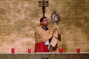 Msgr. James Shea offers a blessing with the Blessed Sacrament during his virtual retreat from Our Lady of Annunciation Chapel on the University of Mary campus. 