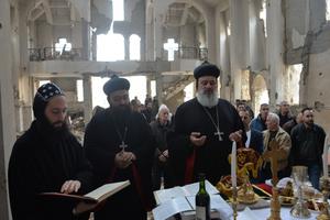 Above, Syriac Orthodox Patriarch of Antioch Ignatius Aphrem II celebrates Holy Qurobo Mass over the ruins of the (Syriac Orthodox) Virgin Mary Church in Deir ez-Zour, Syria.
Below, Patriarch Ignatius Aphrem walks through the streets of the ravaged city.