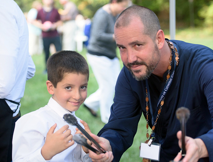 Father Hezekias Carnazzo and his son Carlino serve guests at the Institute of Catholic Culture’s 10th anniversary party.