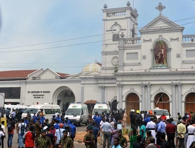 Ambulances are seen outside the church premises with gathered people and security personnel following a blast at the St. Anthony's Shrine in Kochchikade, Colombo on April 21, 2019. 