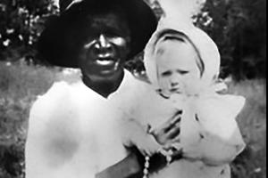 Above, the only photograph of Julia Greeley known to exist shows her holding 7-month-old Marjorie Ann Urquhart. Urquhart’s mother told Julia she had lost a child 13 years prior and was told she couldn’t have any more children. Greeley prayed for her, and, the next year, Marjorie was born. Below, Archbishop Samuel Aquila signs the oath pledging to fulfill faithfully the task of the cause and blesses the crowd at the Dec. 18 Mass.

