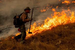 A firefighter watches over a back fire along a hillside during firefighting operations to battle the Kincade Fire in Healdsburg, California, on Oct. 26.  
