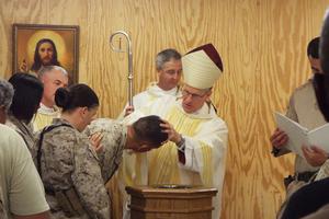 Archbishop Timothy Broglio baptizes military personnel.
