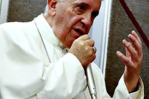Pope Francis talks to journalists during a press conference he held while en route to Italy on Sept. 28.
