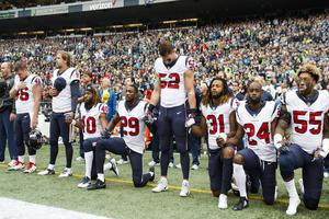Members of the Houston Texans kneel and stand during the national anthem during an NFL football game against the Seattle Seahawks Oct. 29 in Seattle.