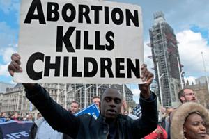 Man holds a sign at the March for Life in London, England, May 11, 2019. 