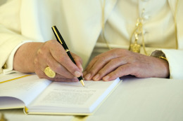 Pope Benedict XVI signs a copy of his encyclical Caritas in Veritate at the Vatican.