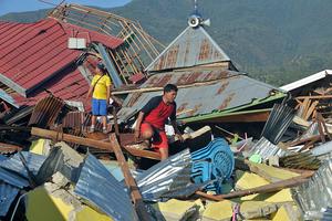 People inspect damaged houses in Palu Oct. 1, after an earthquake and tsunami hit the area Sept. 28. 