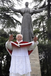 Benedict stands beneath Pius XII statue in Rome.