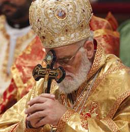 Melkite Patriarch Gregoire III Laham of Damascus, Syria, holds a crucifix as he prays during the closing Mass of the Synod of Bishops for the Middle East in St. Peter's Basilica at the Vatican Oct. 24.