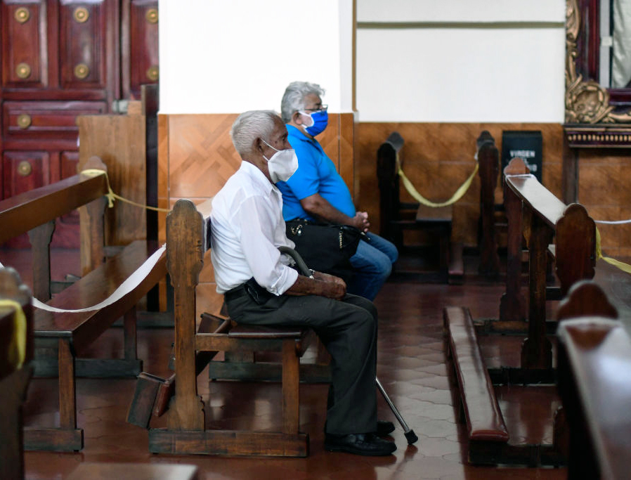Parishioners pray at a church during the celebration of the feast of St. Christopher, patron saint of travelers and drivers, in Guatemala City on July 30, 2020, amid the COVID-19 pandemic.