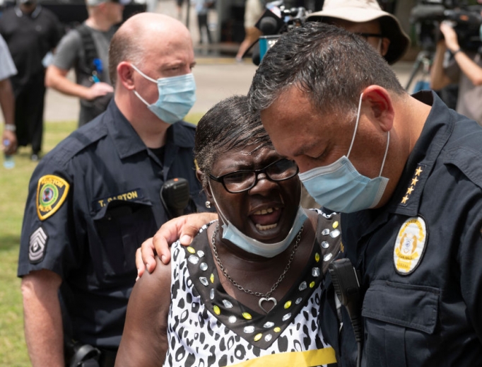 Houston Police Chief Art Acevedo prays with a woman while people wait in line to attend the public viewing for George Floyd at the Fountain of Praise church in Houston on June 8.