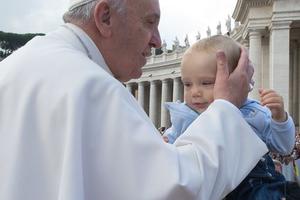 Pope Francis greets a baby at his Oct. 7 Wednesday general audience in St. Peter’s Square.