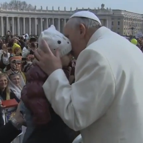 Pope Francis kisses a child during his Feb. 26 general audience in St. Peter's Square.