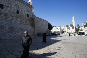 A priest walks in the Church of the Nativity compound in the occupied West Bank city of Bethlehem on March 8, after it came under lockdown two days ago as an emergency measure to limit the spread of the novel coronavirus. 