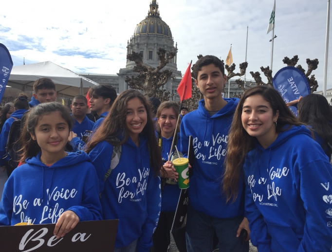 Above, teens attend the Walk for Life West Coast 2020 with Vox Vitae; below, Father Frank Pavone of Priests for Life and students from St. Joseph Academy pose for a photo in front of the San Francisco cathedral. Also below: Liz from Our Lady of Peace parish, along with her family, attends the walk, and seminarians from St. Patrick’s Seminary show their support for life. Bottom of page: Yoselin Donas, r, and her family attend the 16th-annual pro-life event.