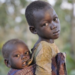 A girl carries her sibling on her back in Pisak, a village in Southern Sudan's Central Equatoria state.