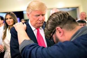 Pastor Joshua Nink prays with Republican presidential candidate Donald Trump, who was raised Presbyterian, after a service at First Christian Church on Jan. 31 in Council Bluffs, Iowa. Below, Hillary Clinton attend a service at the First United Methodist Church in Huntington, W. Va.