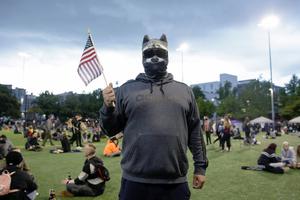 A man who wished to remain anonymous is pictured wearing a raccoon mask in an area being called the Capitol Hill Autonomous Zone (CHAZ) located around streets reopened to pedestrians after the Seattle Police Department's East Precinct was vacated in Seattle, Washington on June 12, 2020.