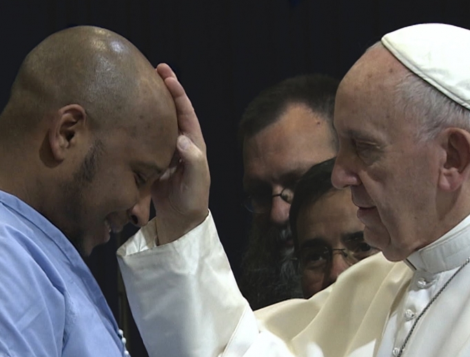 Above, footage of Pope Francis blessing an inmate from Pope Francis: A Man of His Word. Below, director Wim Wenders and Pope Francis.