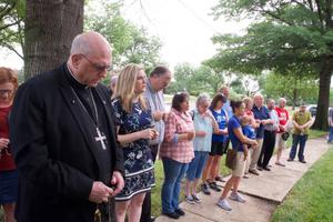 Archbishop Joseph Naumann leads the Rosary in front of Planned Parenthood in Overland Park, Kansas, praying along with archdiocesan pro-life coordinator Allison Donohue (in patterned navy dress) and others. 