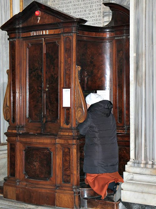 A priest hears a woman's confession at the Vigil for Life at the Basilica of St. Mary Major in March.